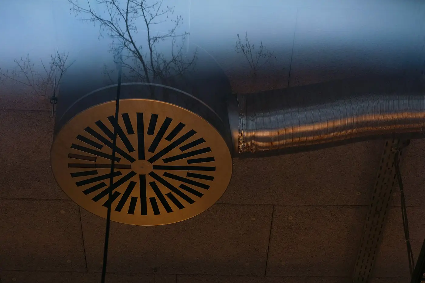 Round ceiling air diffuser connected to flexible ductwork