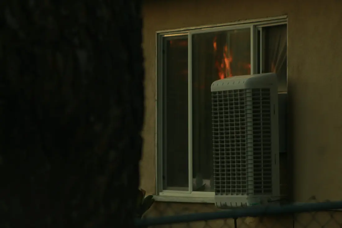 Window-mounted evaporative cooler at dusk